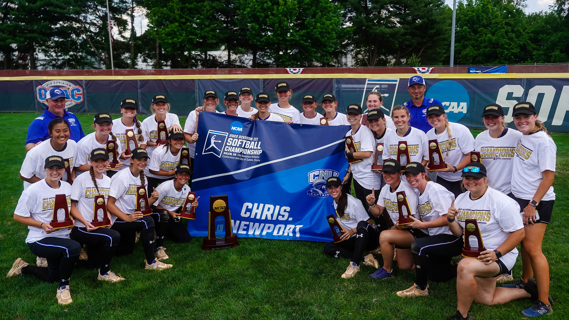 The CNU Softball team holds their banner and national championship trophy