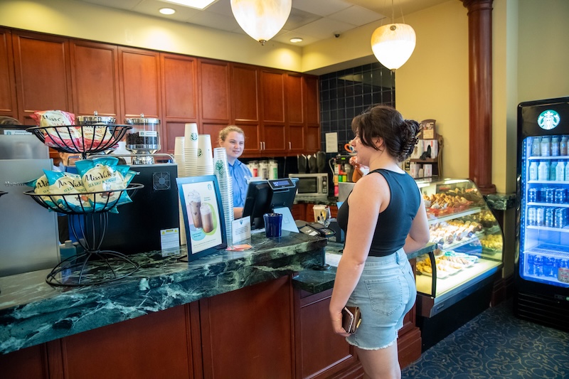 Student standing at the Einstein's counter ordering a coffee