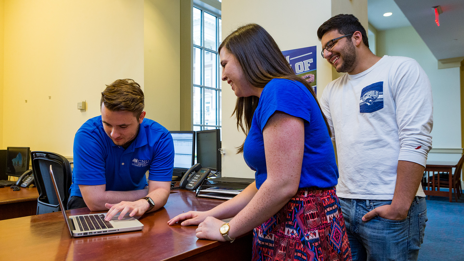 ITS student worker helping another student with their laptop