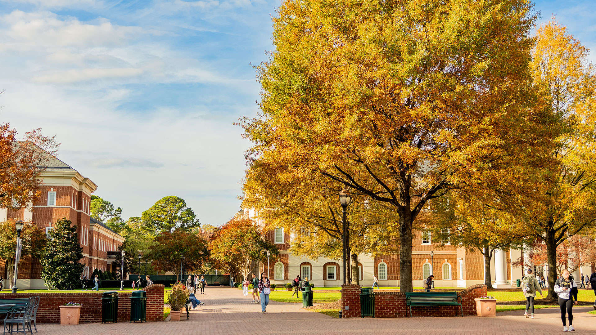 Trible Plaza in fall with students and trees displaying yellow-orange foliage.