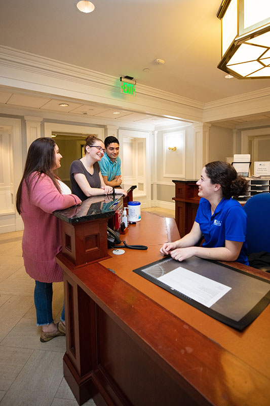 Students in a residence hall talking with a Residential Fellow