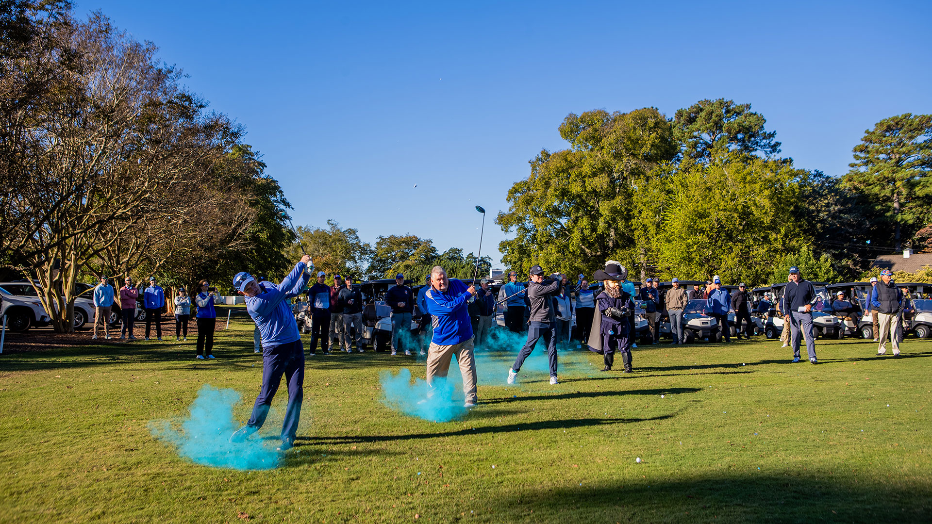 A group of men hitting a golf ball that turns to blue smoke after the ball is hit.