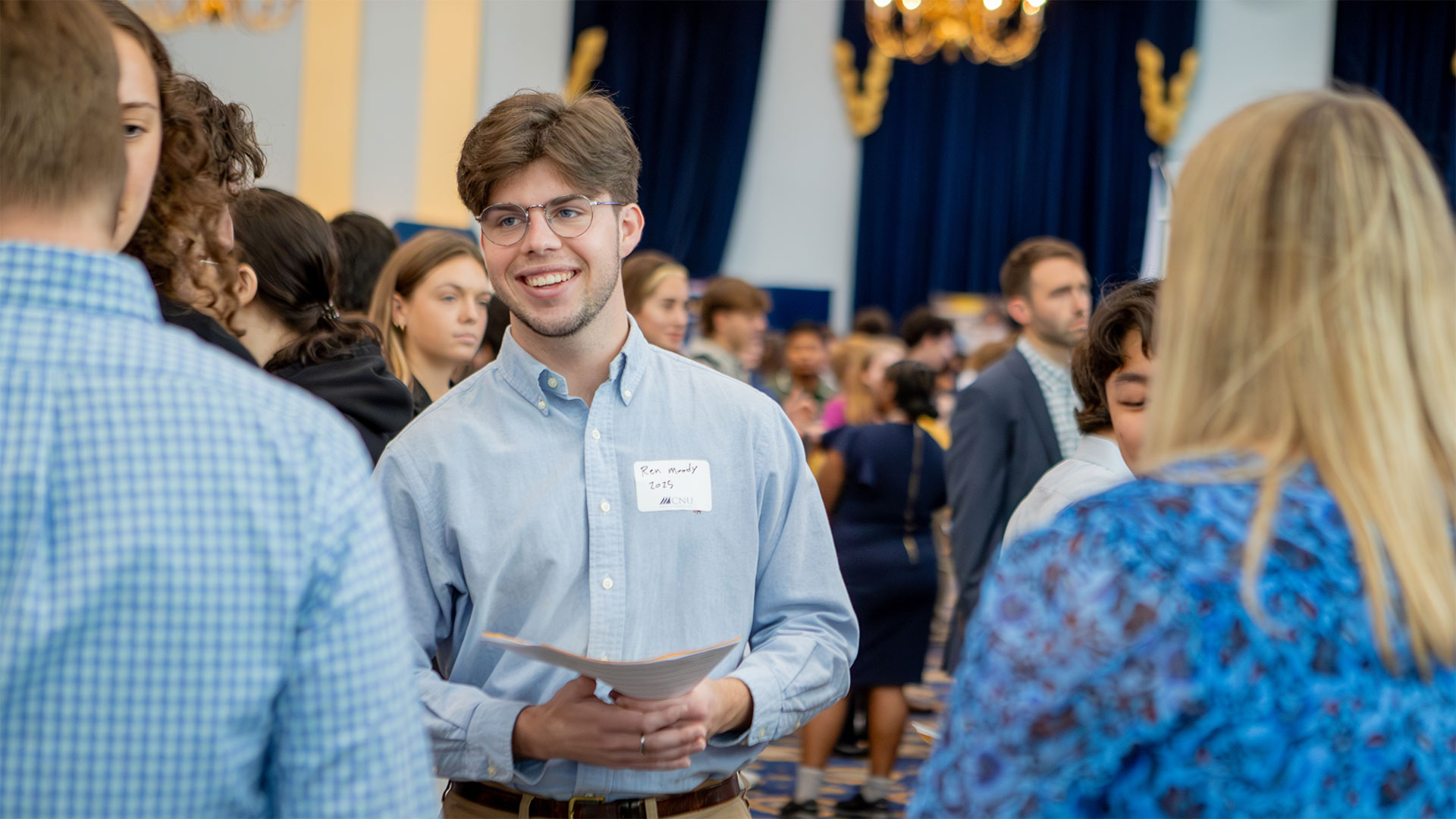 A student looks on and listens to a recruiter during a job fair