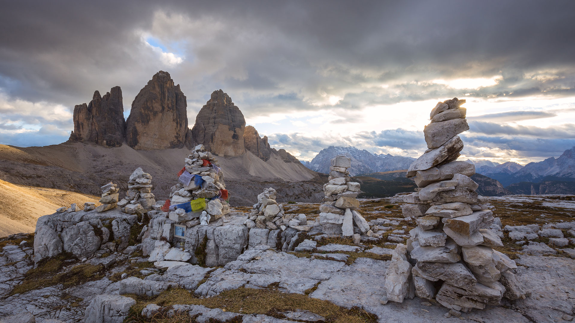 Rocks stacked on top of each other on a mountain top surrounded by other religious objects