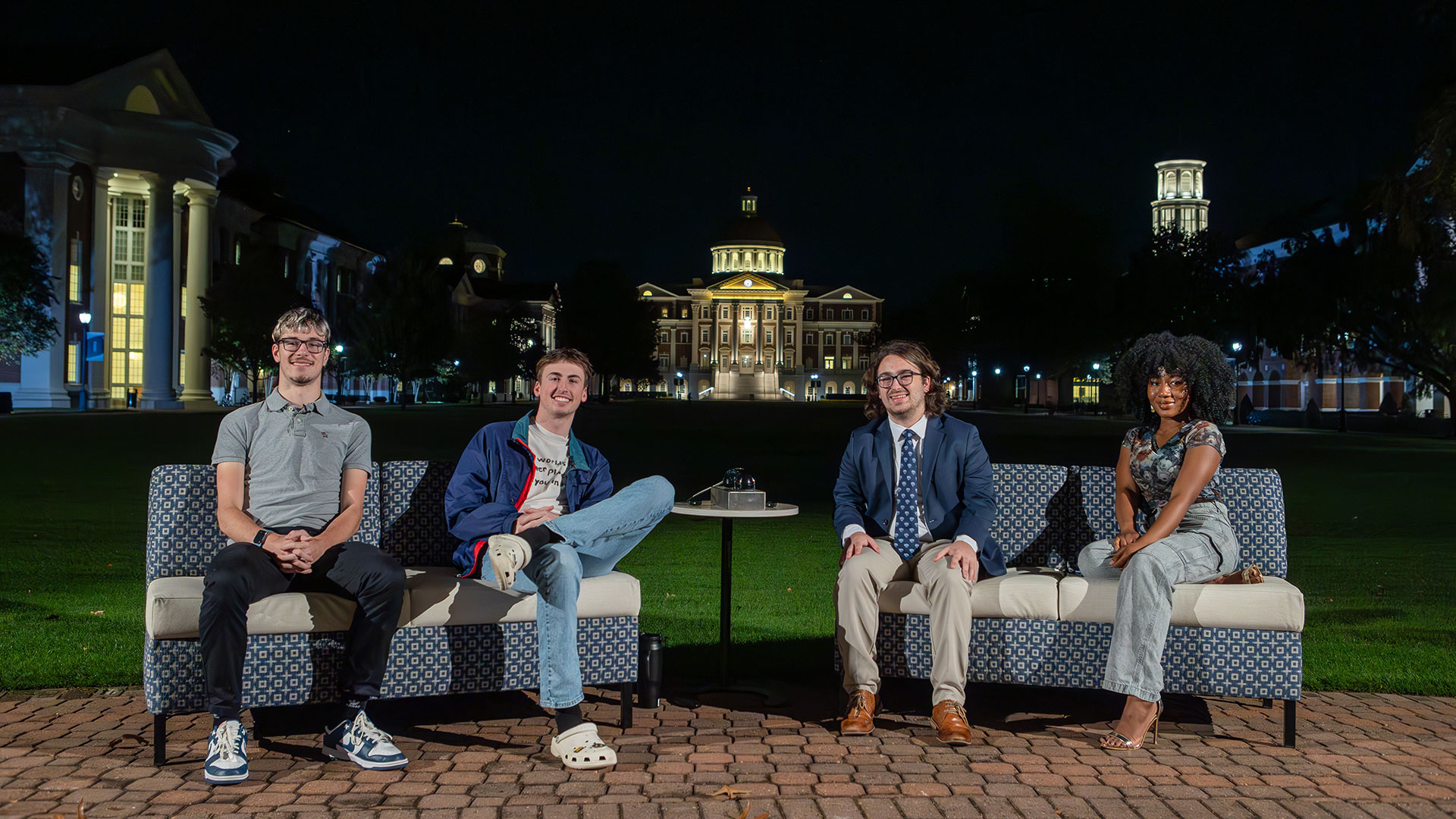 On the Lawn interns on a bench at night with CNH in the background