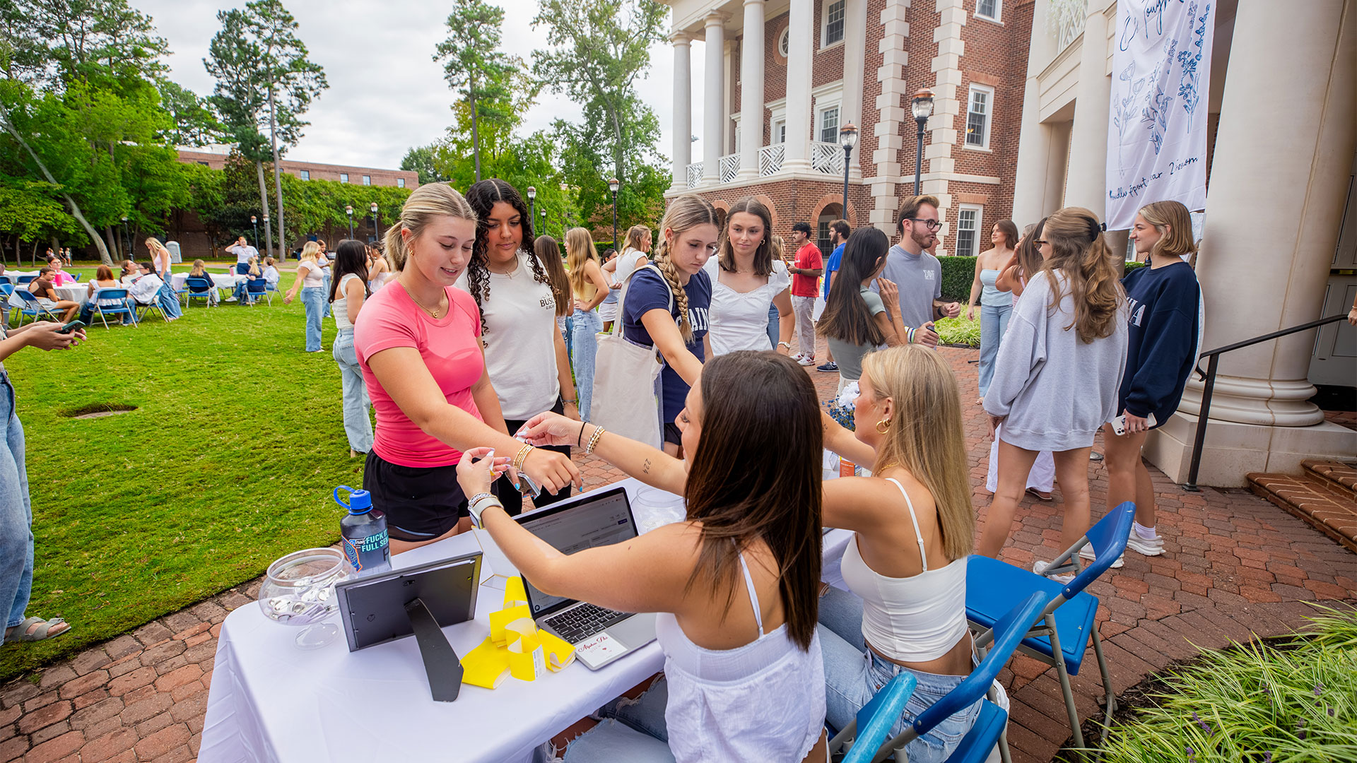 Members of Alpha Phi pass out wristbands at their One Tough Cookie event.