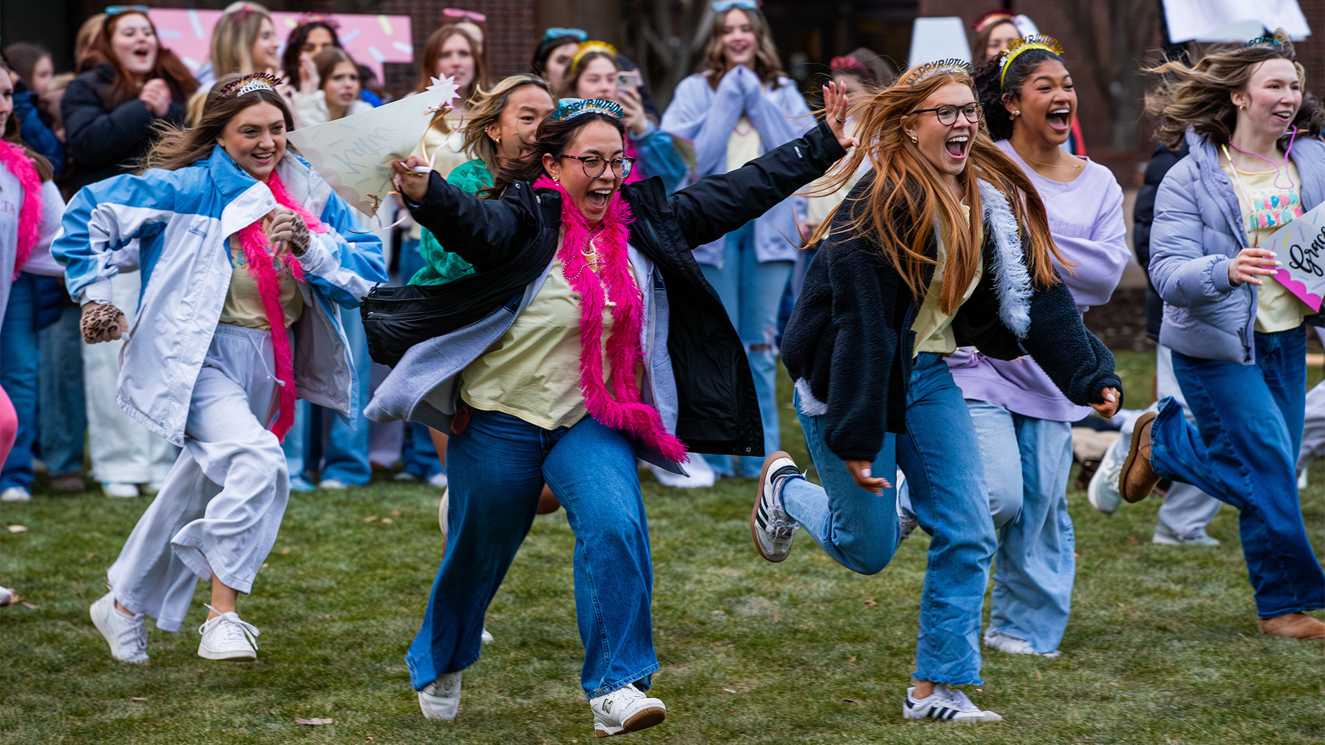 Women run across the lawn to their new sorority chapters at Panhellenic Bid Day 2026.