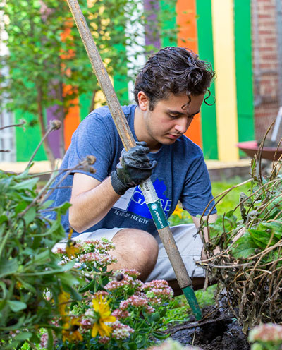 Student volunteering tending garden