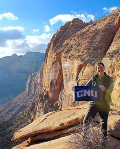 Student holding CNU flag in canyon