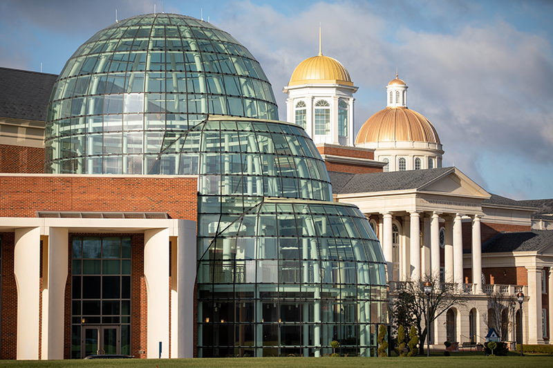 The domes of the Torggler Fine Arts Center shine in the foreground with the background showcasing the golden cupolas of the library and Christopher Newport Hall.