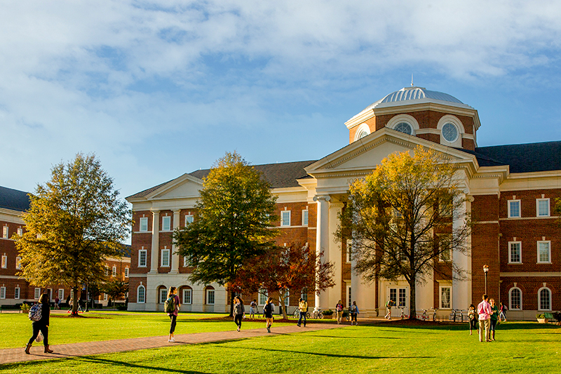 Luter School of Business during the fall season as students walk in front of the building on walkways.