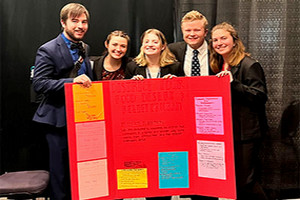 A group of five students holding their poster board during the Leadership Challenge event in Kansas.