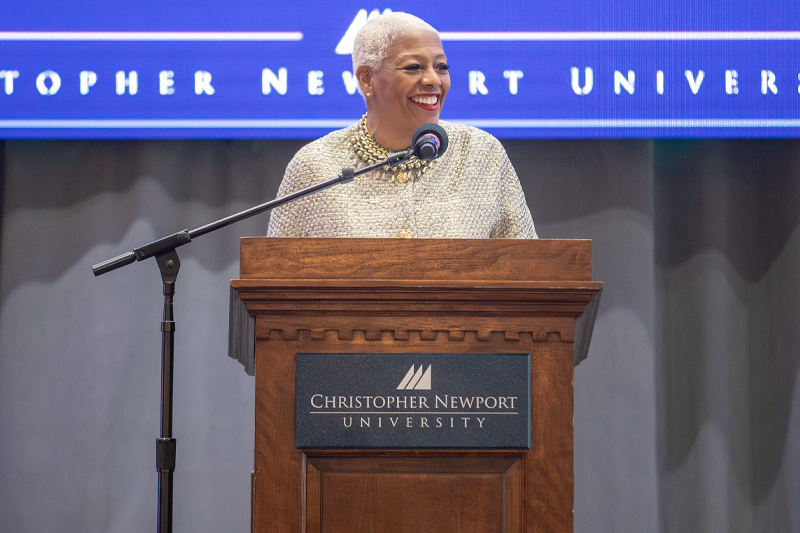Norfolk State University President Dr. Javaune Adams-Gaston stands at a podium while speaking to an audience