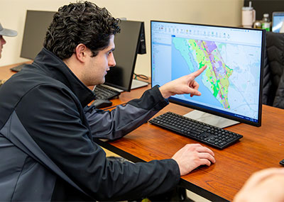 A student points at a computer screen that shows a map of Newport News.