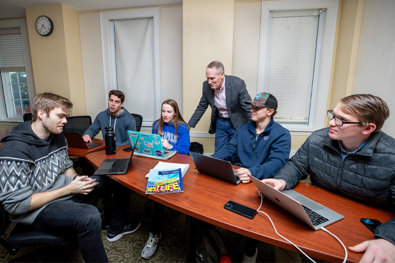 Students sitting around table with professor