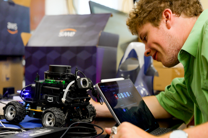 A student works intensely on a robot.