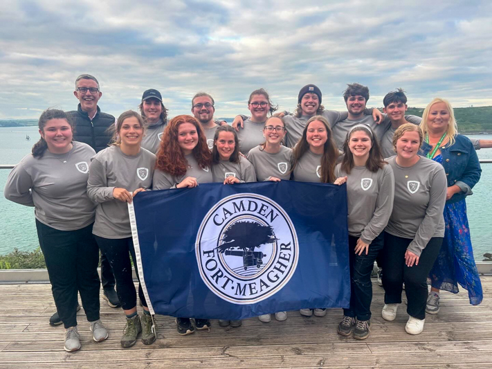 A group of students stand together while holding Camden Fort-Meagher flag.