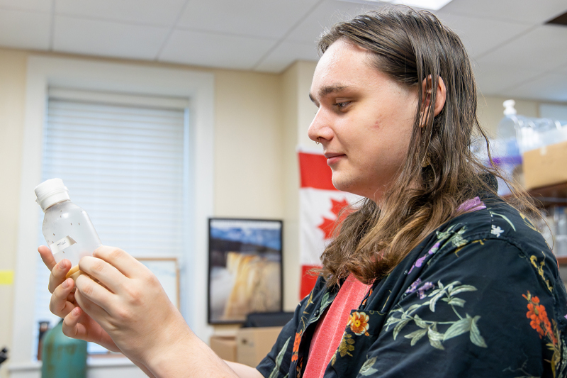 Curtis Patton studies a container of fruit flies.