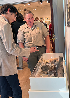 A student and professor look at an exhibit under glass