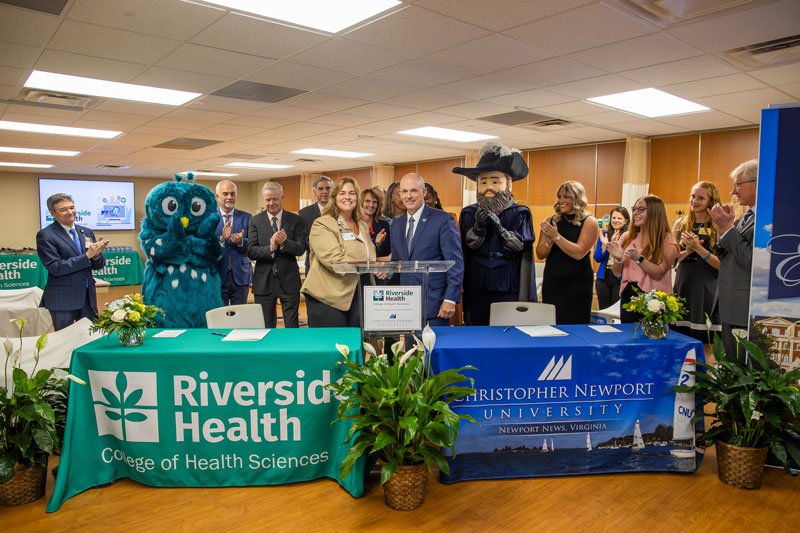 Members from Riverside College of Health Sciences and CNU shake hands. 