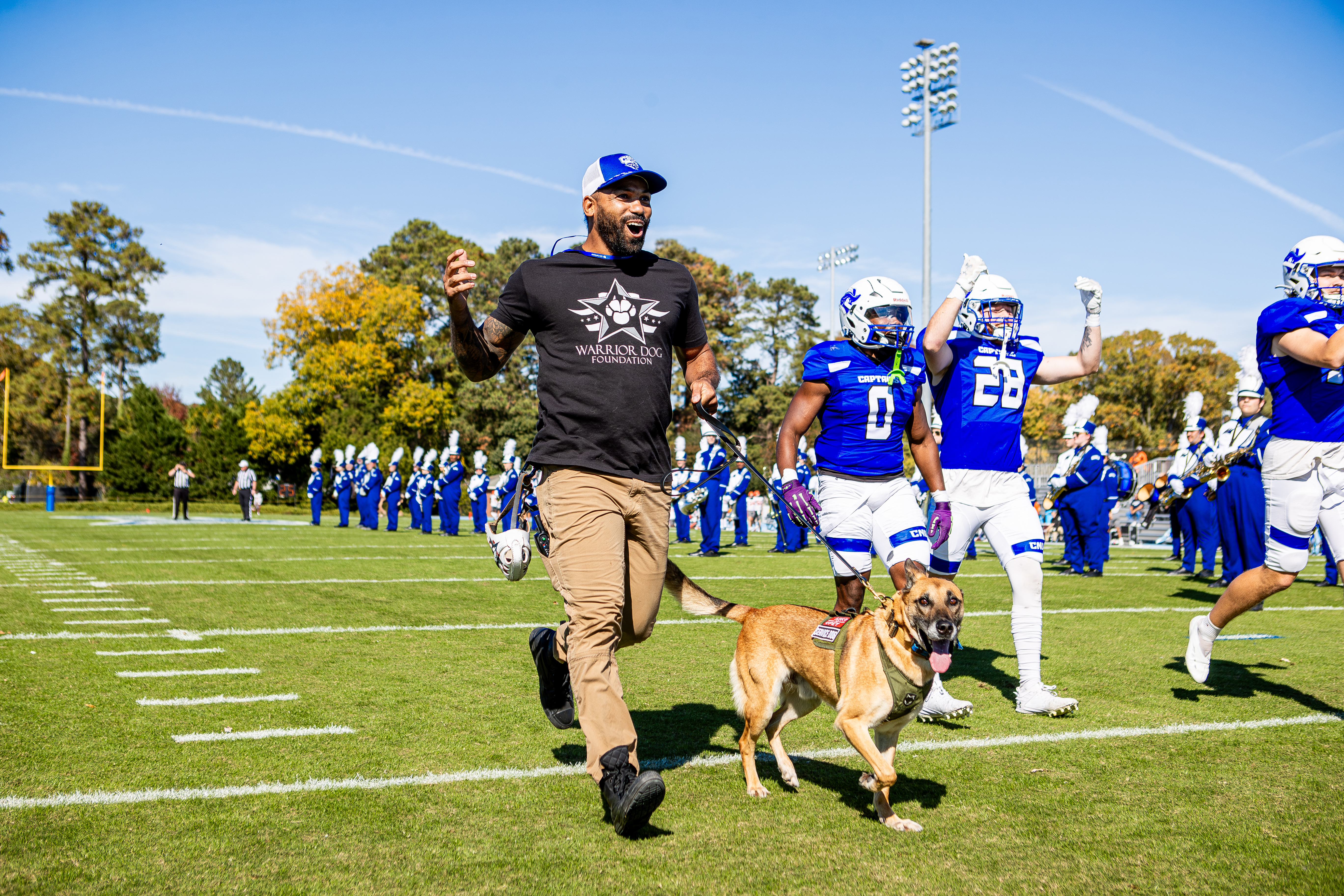 Chris Cappa runs with his dog alongside some CNU football players.