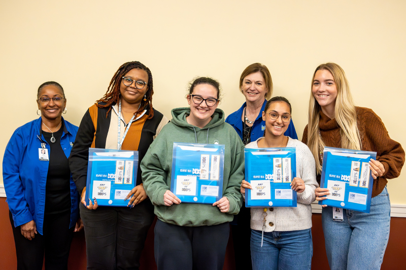 Students  stand with their offer letters and staff members from NNPS.