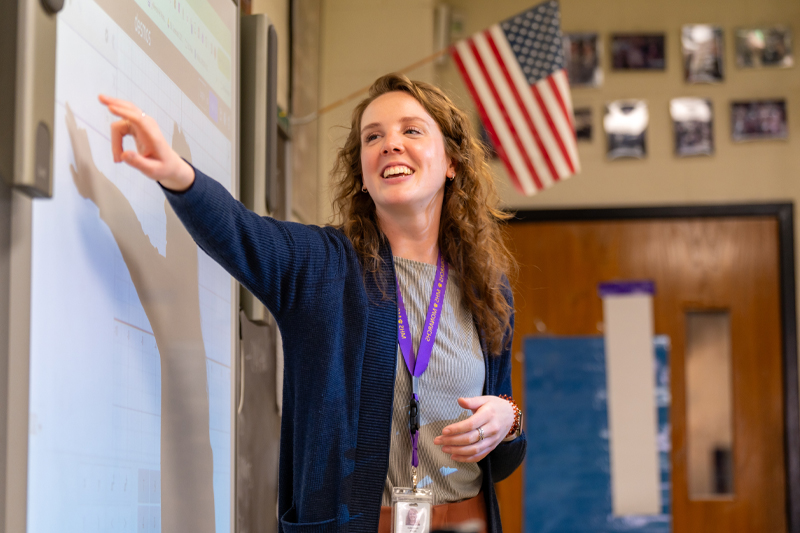 A woman points at a whiteboard