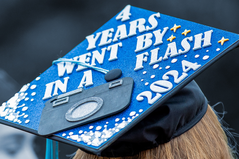 decorated graduation cap that says 4 years went by in a flash, 2024 with a picture of a camera