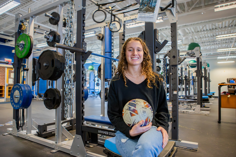 Jaya Daniel in a weight room with a soccer ball