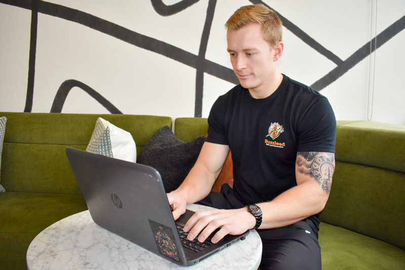 Troy Aiken '18 sits in front of a laptop.