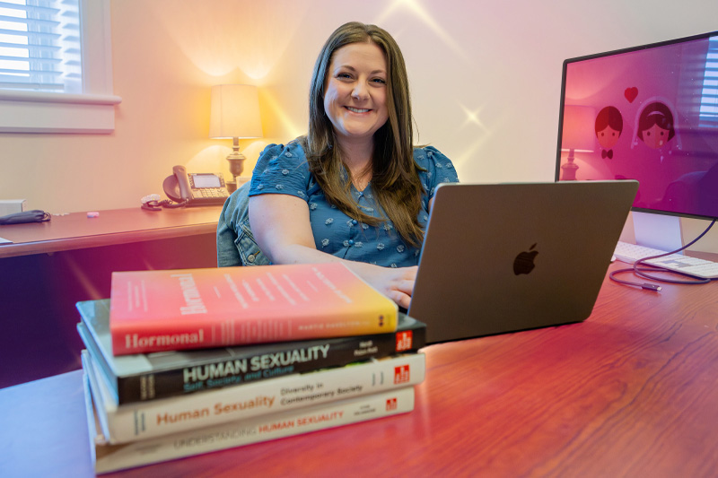 Woman smiling while working on laptop