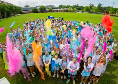 Students covered in colored powder jump