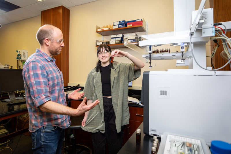 Faculty helping student in a lab