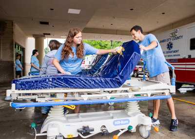 Students wipe down a gurney at a local hospital