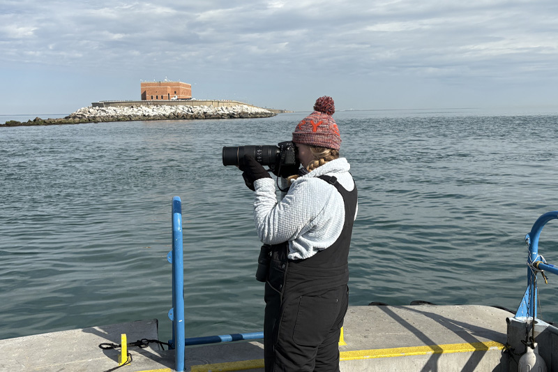 Michelle Guins looking through a camera lens