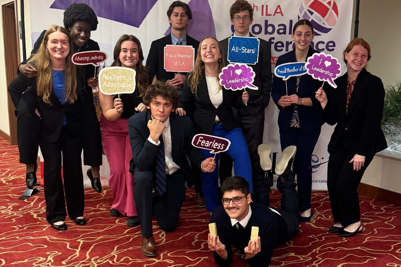 Students posing with various celebration signs
