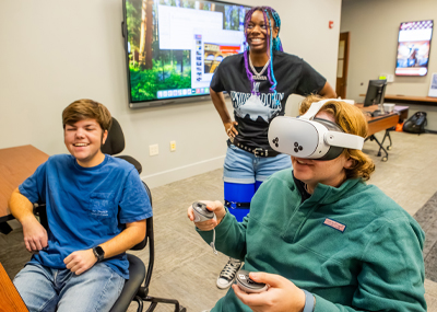 Two students smiling while using virtual reality headset