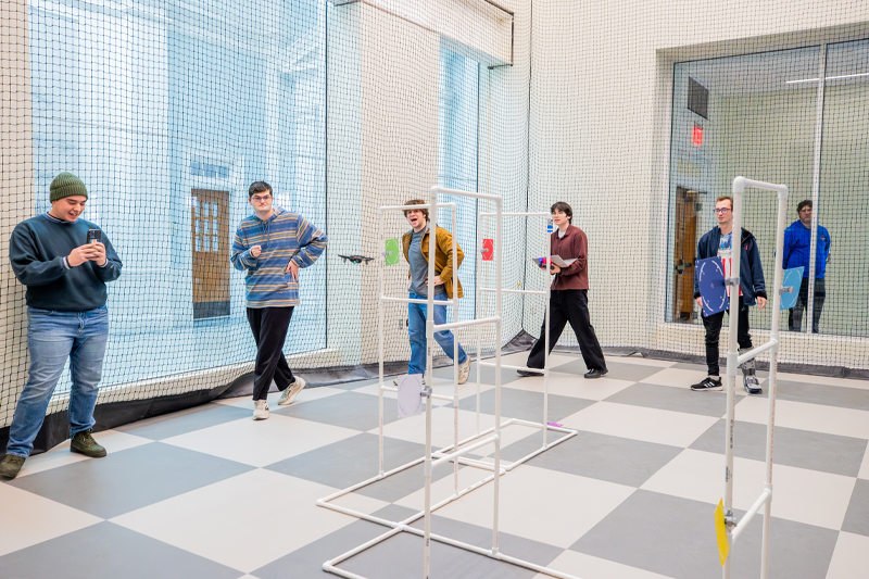 Four students looking over notes in new SERC drone lab classroom. 