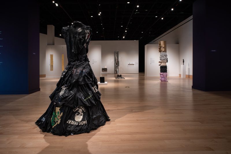 A wide-angle view of the Anne Noland Edwards Gallery featuring a large black sculpture made of layered black band t-shirts in the foreground