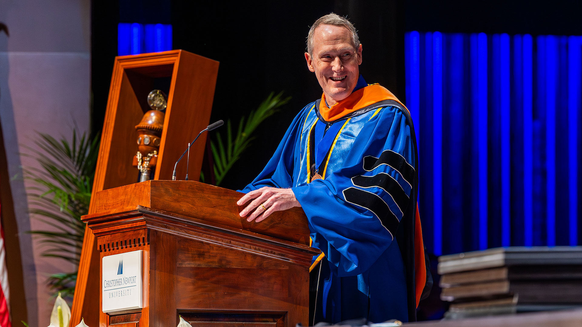 Dr. Willy Donaldson stands at the podium in regalia.