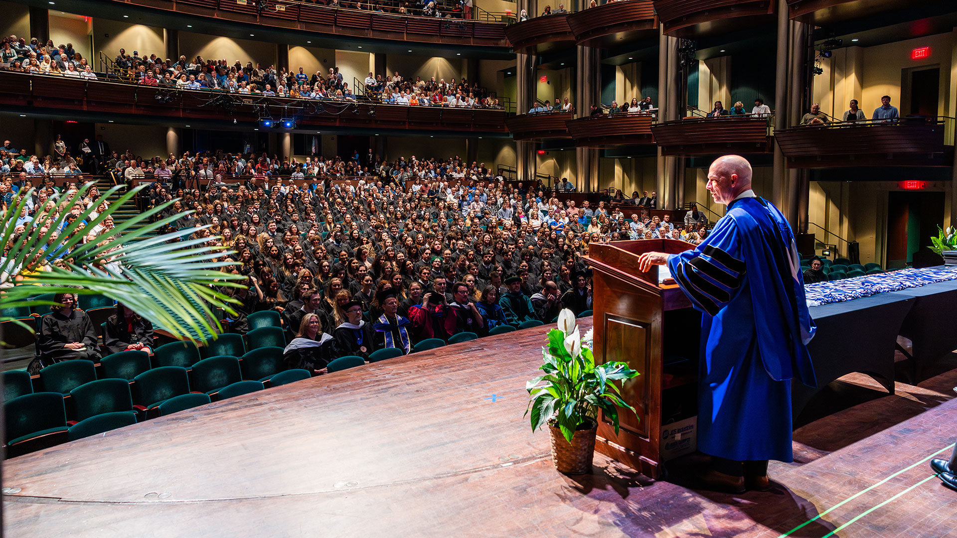 A wide-angle view from the stage looking out at a large, packed auditorium during the Latin Honors Ceremony.