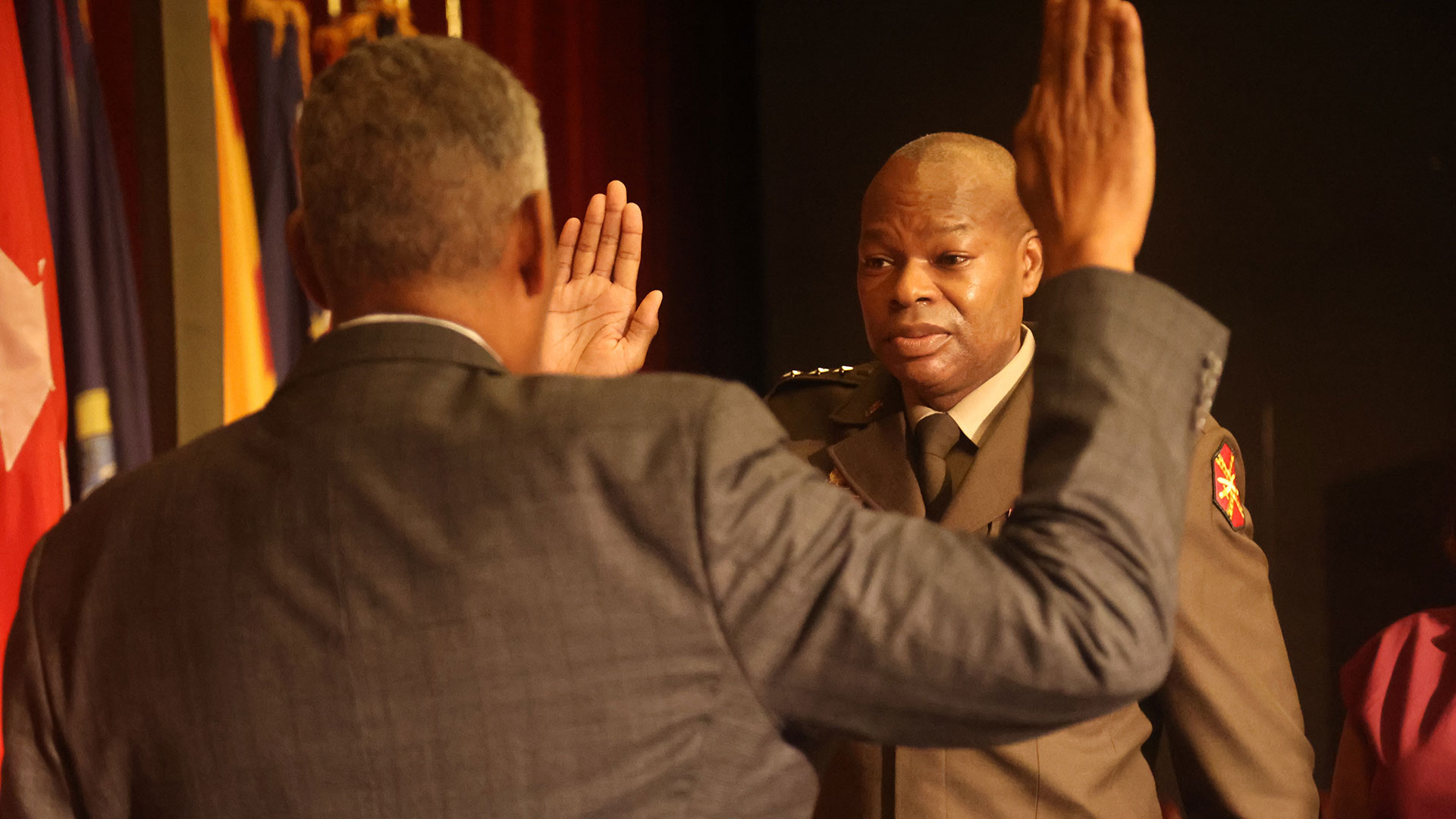 Lt. Gen. James Smith stands at attention with his right hand raised while taking an oath.
