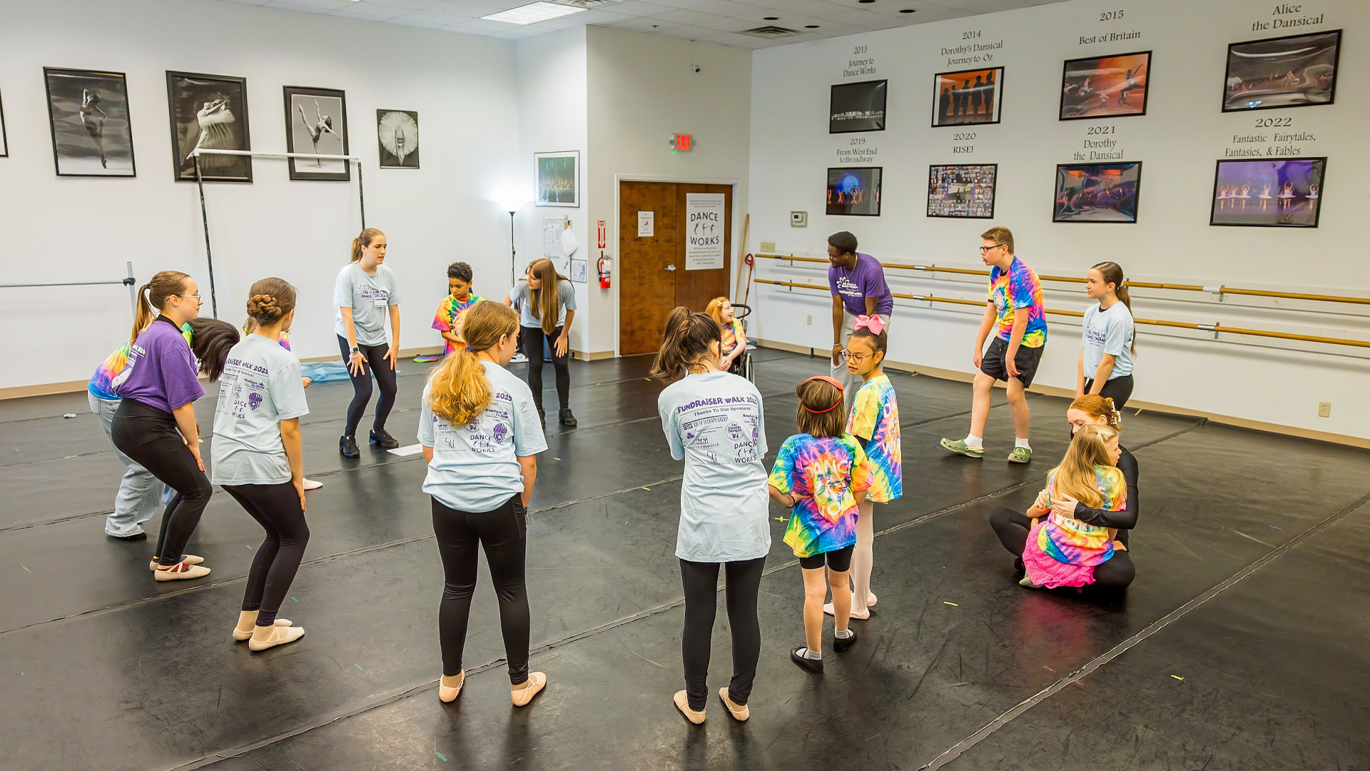 People stand in a dance studio in a circle