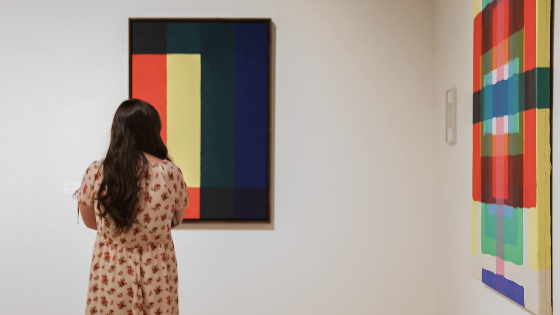 A woman admires artwork by Paul Reed at the Torggler Fine Arts Center