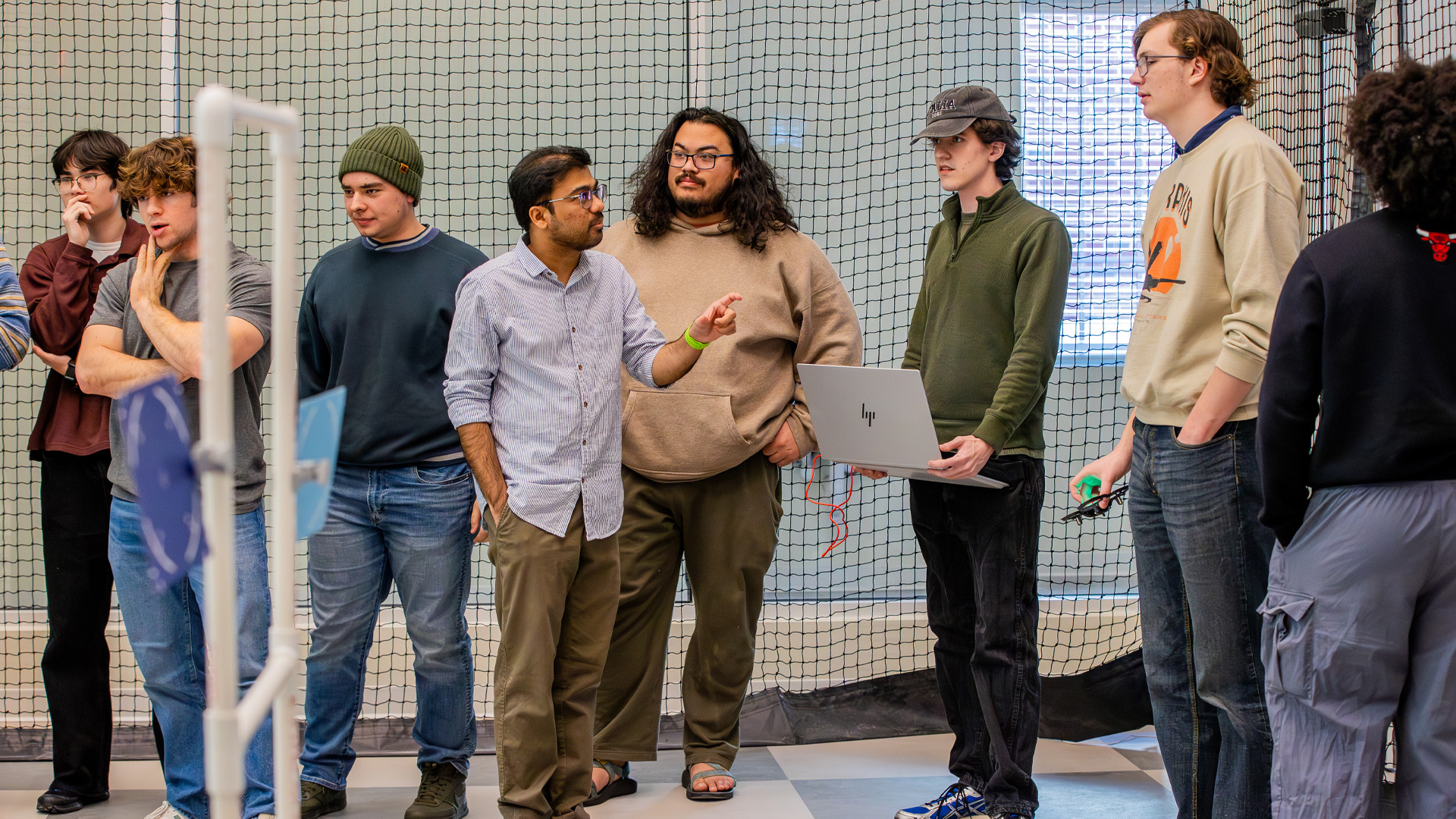 A professor stands in the drone lab with students