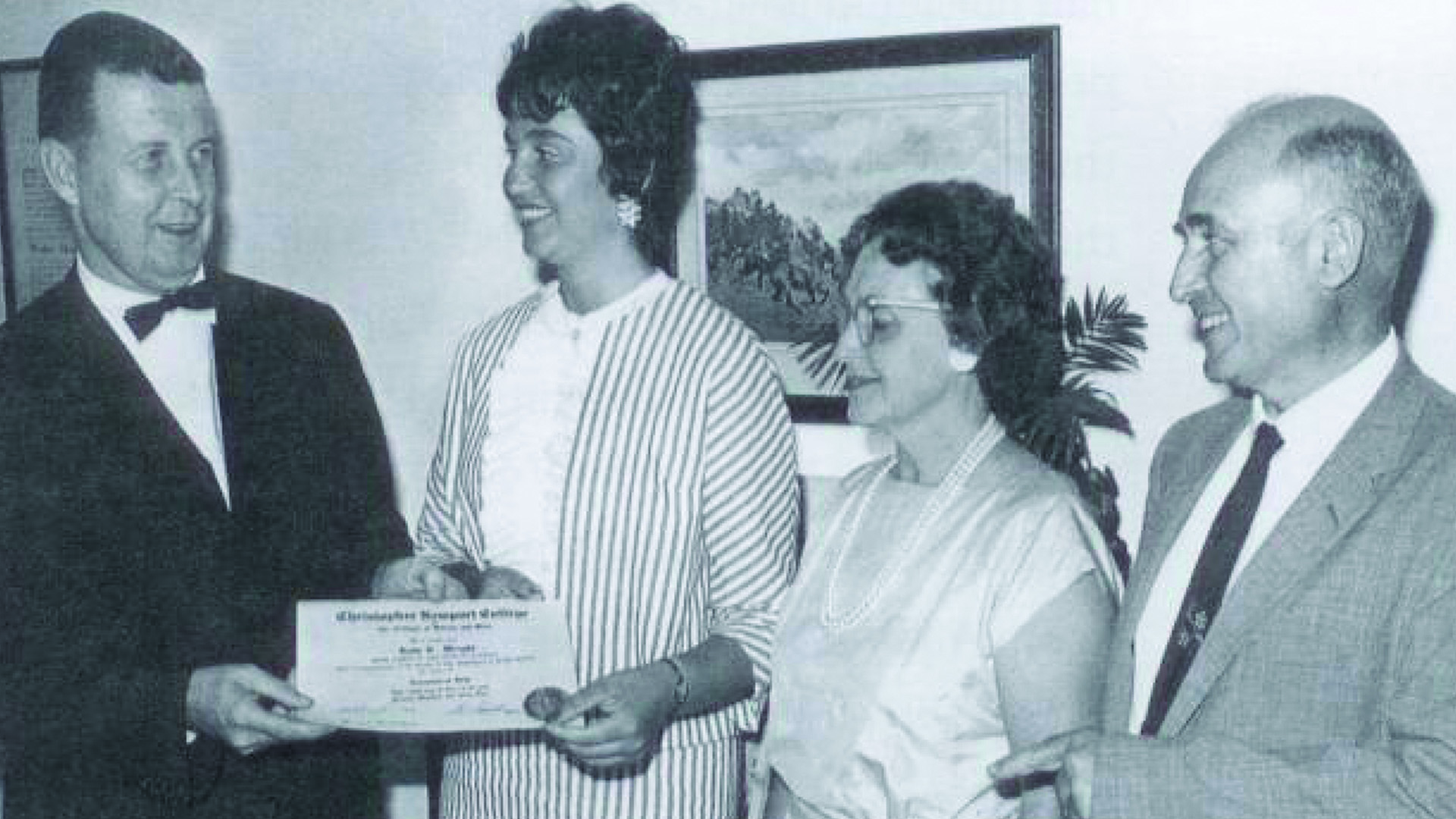 A black and white photo of Lois Wright (second from left) receiving her diploma from H. Westcot Cunningham