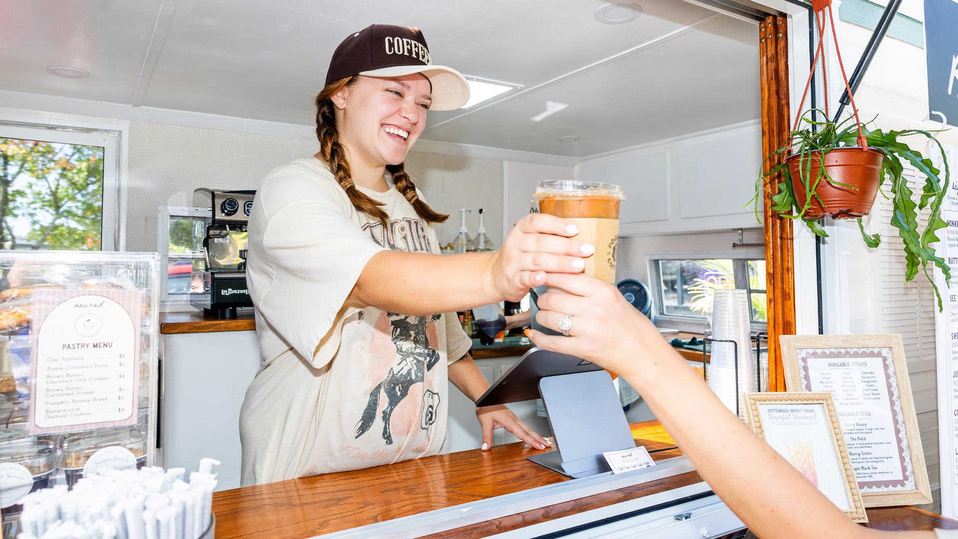 A person hands a cup of coffee to an outstretched hand