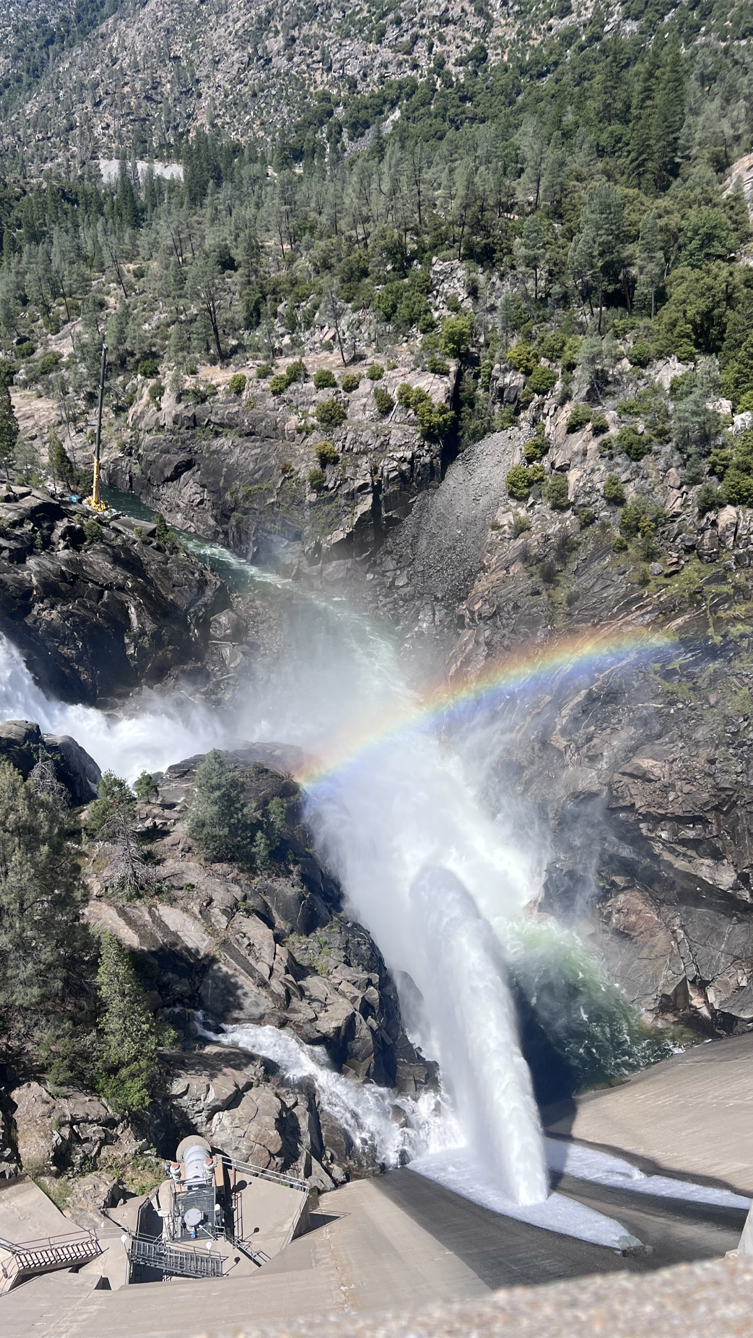Aerial image of a damn with a rainbow 