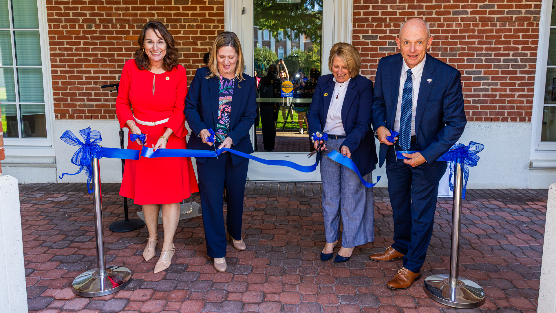 Jennifer Latour, Sarah Herzog, First Lady Angie Kelly and CNU President Bill Kelly cut the ribbon to open the HELM convenience store.