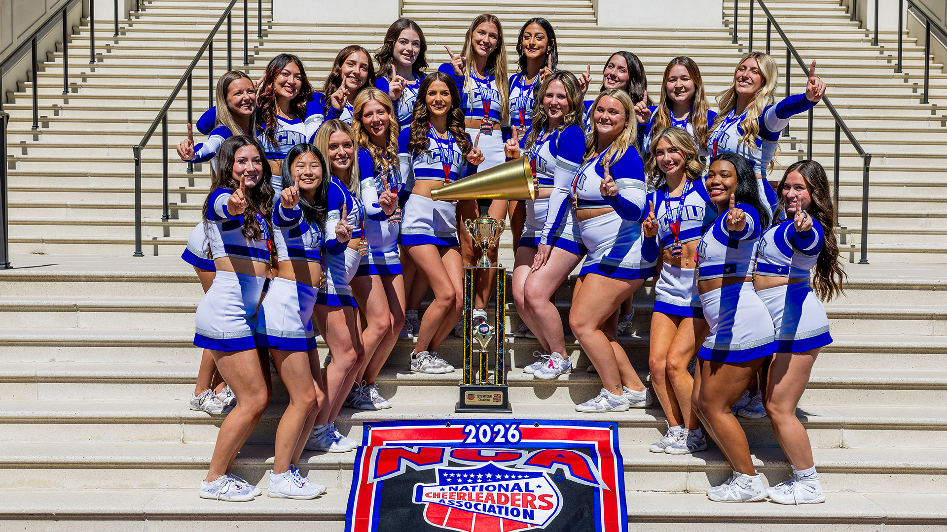 Cheerleading team standing on the steps of Christopher Newport Hall